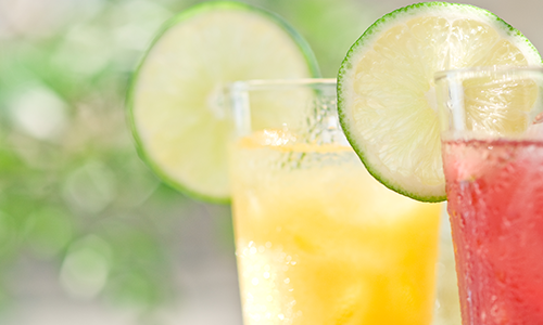 Two refreshing ice-cold beverages with a slice of lime